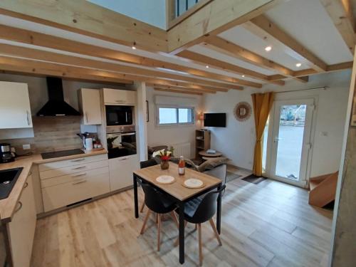 une cuisine et une salle à manger avec une table et des chaises dans l'établissement Le Pommier Gite neuf avec parking privé clos, à Jullouville