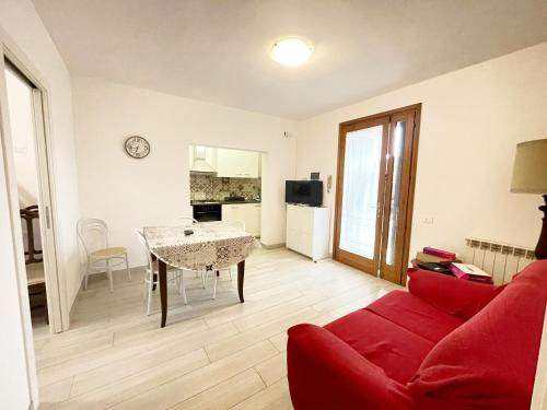 een woonkamer met een rode bank en een tafel bij Casa Berso' a Marina di Cecina by Zoom In Earth in Marina di Cecina