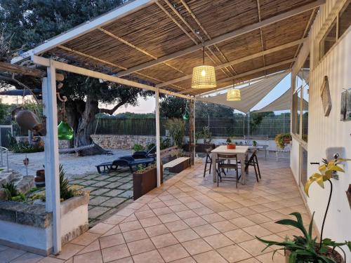 a patio with a table under a wooden pergola at Villa Anna Polignano in Polignano a Mare