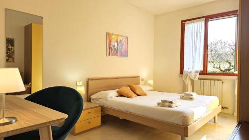 una camera da letto con un letto con un tavolo e una scrivania di APARTMENT ORTENSIA - Regarda Travel a Lazise