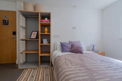 a bedroom with a bed and a book shelf at Canvas The Old Fire Station Birmingham in Birmingham