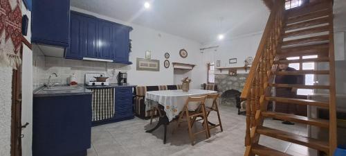 a kitchen with a white table and blue cabinets at Παραδοσιακο Αρχοντικό της Αλεξάνδρας in Samothráki