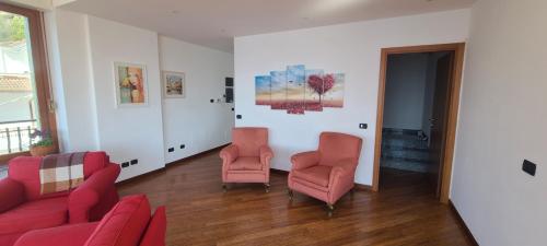 a living room with two chairs and a couch at Villa gli Ulivi - Bariloche Lake & Mountain View in Perledo