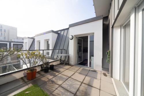 Cet appartement dispose d'un balcon offrant une vue sur un bâtiment. dans l'établissement Terrace - Private Parking - Subway 2 min, à Maisons-Alfort