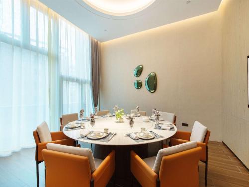 a dining room with a table and chairs at Novotel Wuxi in Wuxi
