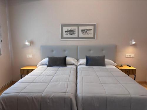 two large beds in a room with two tables at Hotel Ros Mary in Ribadeo