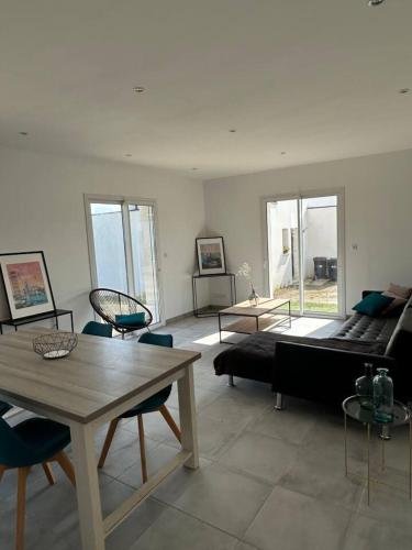 un salon avec un canapé, une table et des chaises dans l'établissement Maison familiale spacieuse à Plouguerneau avec jardin, à Plouguerneau