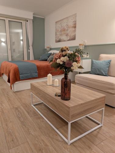 - un salon avec un lit et un vase de fleurs sur une table dans l'établissement Luxury studio next to beaches and old town Antibes, à Antibes