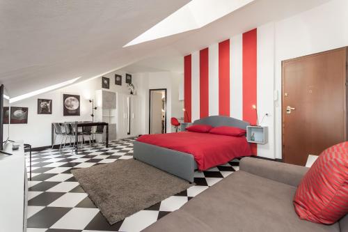 a bedroom with a red bed and a checkered floor at La Mansarda del Principe, vicoli, acquario e lanterna in Genoa