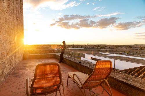 two chairs sitting on a balcony with the sunset at Pousada Mosteiro do Crato in Crato