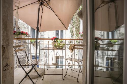 a patio area with a table, chairs and umbrella at Centro di Centri Rooms in Split