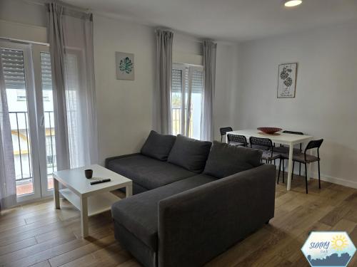 a living room with a couch and a table at Sunny Churriana Jacaranda in Málaga