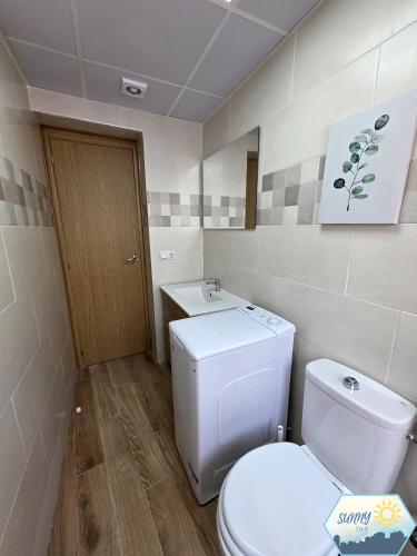 a bathroom with a white toilet and a sink at Sunny Churriana Jacaranda in Málaga
