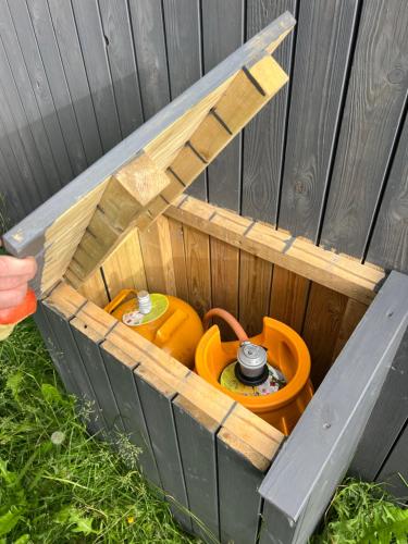a wooden bird house with a potty and a lid at Eyja Mork - Stargazing Igloo with shared Hot Tub, BBQ and kitchen - B3 in Stora Mork