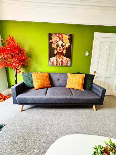 a couch in a living room with a green wall at Best Offer Spacious and Chic 2 Bed Apartment in Plymouth
