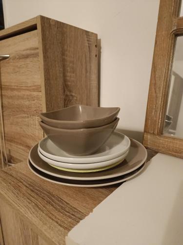 une pile de assiettes et de bols assises sur un comptoir dans l'établissement Châteauneuf du Pape - Chez Marie dans logement ancien atypique - 1 chambre - 1 balcon avec vue - 1 salle d'eau privée, à Châteauneuf-du-Pape