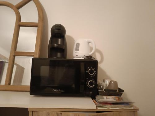 - un four micro-ondes sur un comptoir avec une cafetière dans l'établissement Châteauneuf du Pape - Chez Marie dans logement ancien atypique - 1 chambre - 1 balcon avec vue - 1 salle d'eau privée, à Châteauneuf-du-Pape