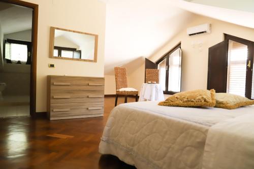 a bedroom with a large bed and a mirror at IL Tetto Di Guardia in Guardia Sanframondi