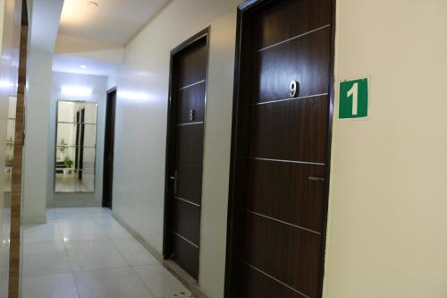 a hallway with dark wood doors and a number at Vinayak Stay Sector 43 in Gurgaon