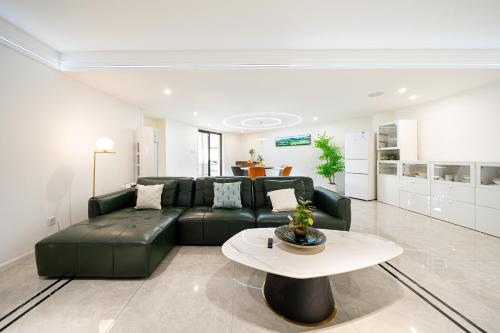 a living room with a green couch and a table at Tonight Homestay South Shanxi Road Shanghai in Shanghai