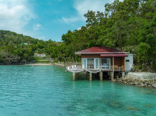 a house on a dock in the water at The Hawk's Nest Resort in Sabong