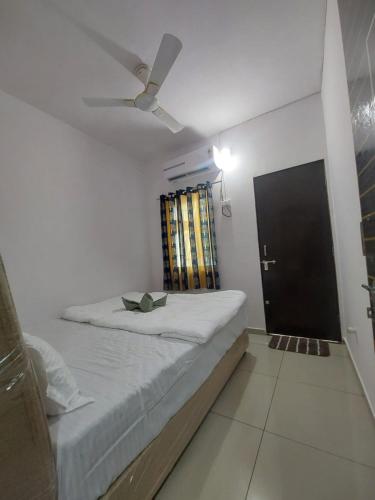 a bedroom with a bed and a ceiling fan at Madhavrai rooms in Kevadia