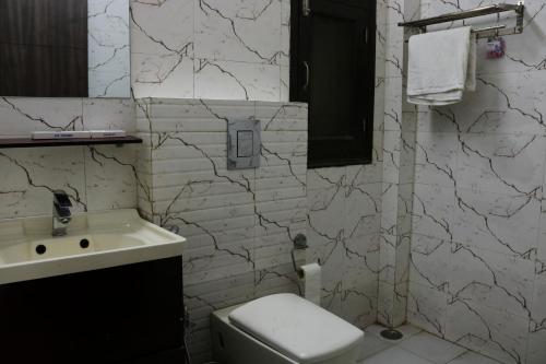a bathroom with a toilet and a sink at Vinayak Stay Sector 43 in Gurgaon