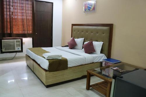 a bedroom with a bed and a table and a television at Vinayak Stay Sector 43 in Gurgaon