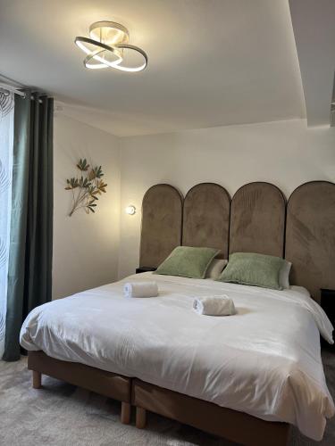 une chambre avec un grand lit avec une grande tête de lit dans l'établissement Hôtel Restaurant Les Boissières, à Bioule