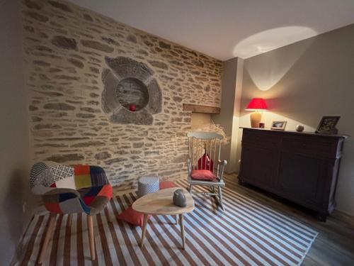 - un salon avec un mur en pierre et une table dans l'établissement Le Clos des Fagettes, à Salles-Curan