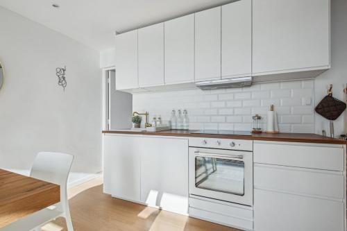 - une cuisine blanche avec des placards blancs et une cuisinière dans l'établissement 9 min de la Basilique Saint-Denis - 10 voyageurs, à Saint-Denis