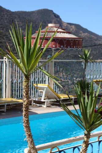 two palm trees next to a swimming pool at Auberge Les Montagnes du Paradis Your Hidden Retreat in Paradise Valley in Agadir