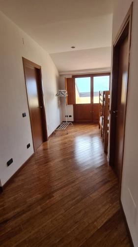 an empty room with a hard wood floor in an apartment at Villa gli Ulivi - Bariloche Lake & Mountain View in Perledo