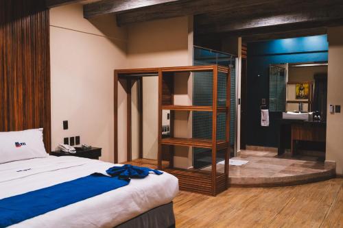a bedroom with a bed and a bathroom with a sink at Motel Caresse in Metepec