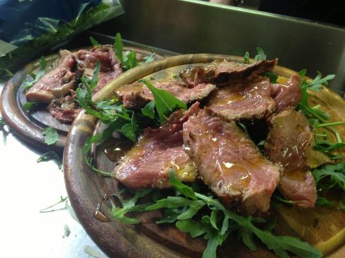a plate of food with meat and greens on it at Tenuta Risalpiano in Pelago