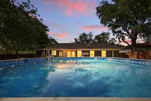 Una gran piscina azul frente a una casa en 5BD,2BA Cheerful Retreat with Backyard, en Dallas