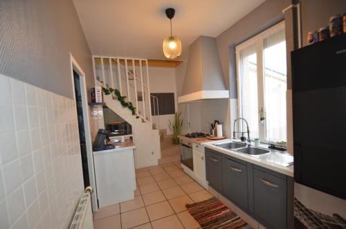 une petite cuisine avec un évier et une fenêtre dans l'établissement APPARTEMENT Zen, à Montluçon