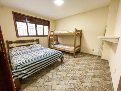a bedroom with two bunk beds and a window at Casa - Temporada in Guarapari