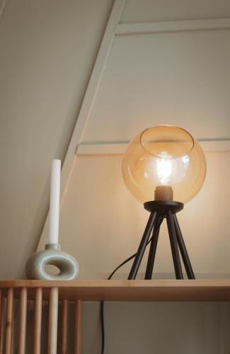 une lampe sur une étagère en bois avec une lumière dans l'établissement Joli appartement 2 pièces proche plage, à Fréjus