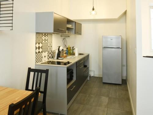 une petite cuisine avec un réfrigérateur et une table dans l'établissement L'Essentiel studio avec wifi, à Cognac