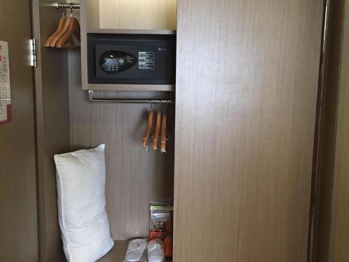 a hotel room with a pillow and a microwave at Kaohsiung Chateau de Chine Hotel in Kaohsiung