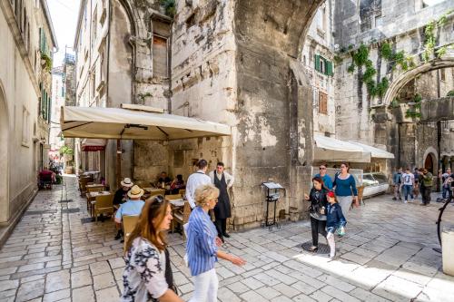 a group of people walking around a city street at Centro di Centri Rooms in Split