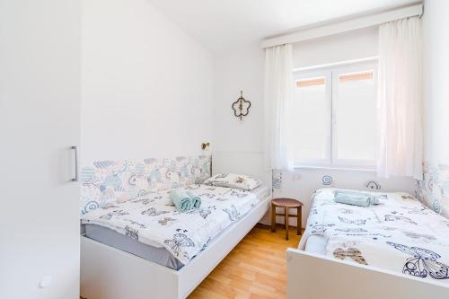 a bedroom with two beds and a window at Apartma Mama Bovec in Bovec