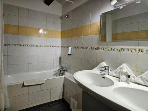a bathroom with a sink and a bath tub at Hôtel Le Mont Barral in Creyers