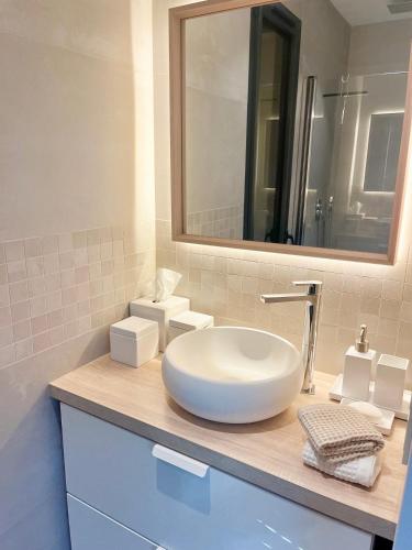 une salle de bain avec un lavabo blanc et un miroir dans l'établissement Villa with pool, petanque, large green space, à Roquefort-les-Pins