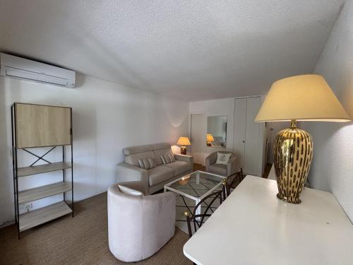 - un salon avec un canapé et une table avec une lampe dans l'établissement Summer Studio by Halldis, à Saint-Tropez