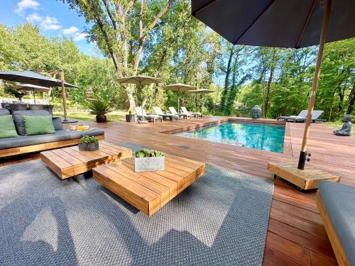 une cour arrière avec une piscine et une terrasse en bois dans l'établissement Villa with pool, petanque, large green space, à Roquefort-les-Pins