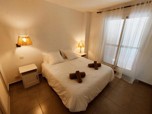 a bedroom with a bed with two brown crosses on it at Puerta Ibiza in Denia
