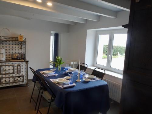 - une table à manger avec une nappe bleue dans l'établissement Ty Mamm Doué, à Ploubazlanec