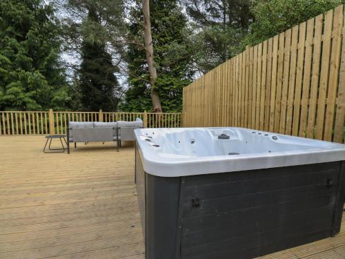 a bath tub sitting on top of a wooden deck at Pickwood Grange in Sowerby Bridge